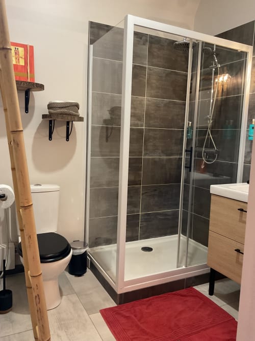 Salle de bain avec douche moderne, finitions soignées, maison d’hôtes à Evry, France, Essonne, hygiène impeccable, confort, espace fonctionnel.