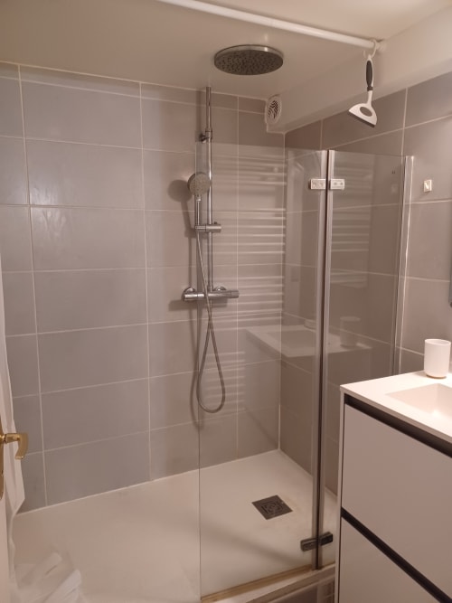 Salle de douche moderne avec pluie de tête à l'appartement Accolade de Châteaudun, murs carrelés et parois en verre