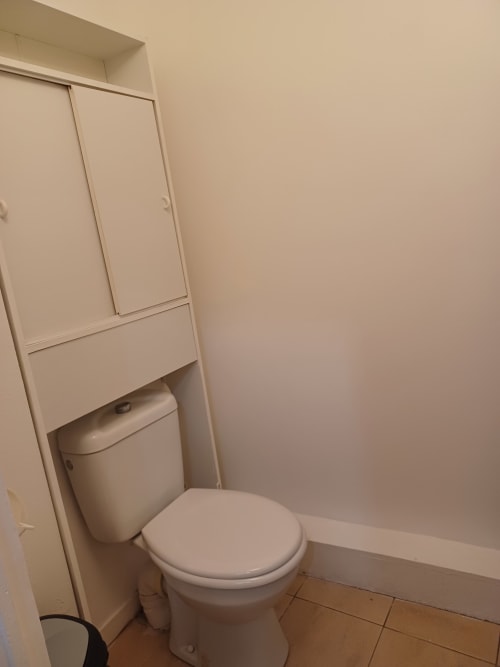 Petite salle de bain avec toilettes blanches et placard de rangement intégré à l'appartement Accolade à Châteaudun, France