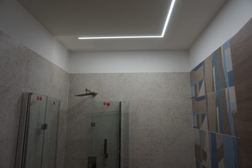 Bagno moderno con piastrelle decorate, box doccia in vetro e luci lineari a soffitto a La Dimora Di Ipno, Vallata