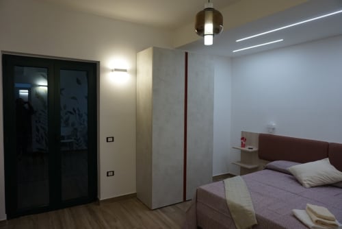 Camera moderna a La Dimora Di Ipno a Vallata con letto, vista montagna, illuminazione a sospensione e arredamento contemporaneo