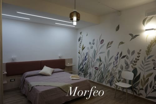 Camera moderna a La Dimora Di Ipno a Vallata con murale botanico, biancheria viola e illuminazione a sospensione