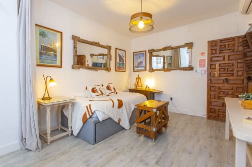 Acogedor estudio en Puerto Santa María con decoración de madera, cama queen, lámparas de latón y vista a la ciudad