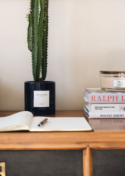 Bureau minimaliste à la Maison D'olivier avec cactus, carnet, livres et bougie à Mesnard la Barotière