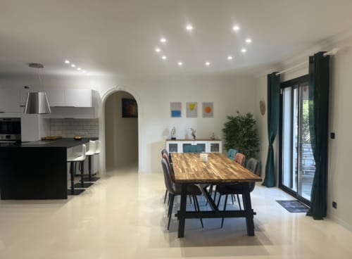 Moderner offener Essbereich und Küche im La Villa des Ecureuils mit Holztisch, zeitgenössischen Stühlen und Gartenblick