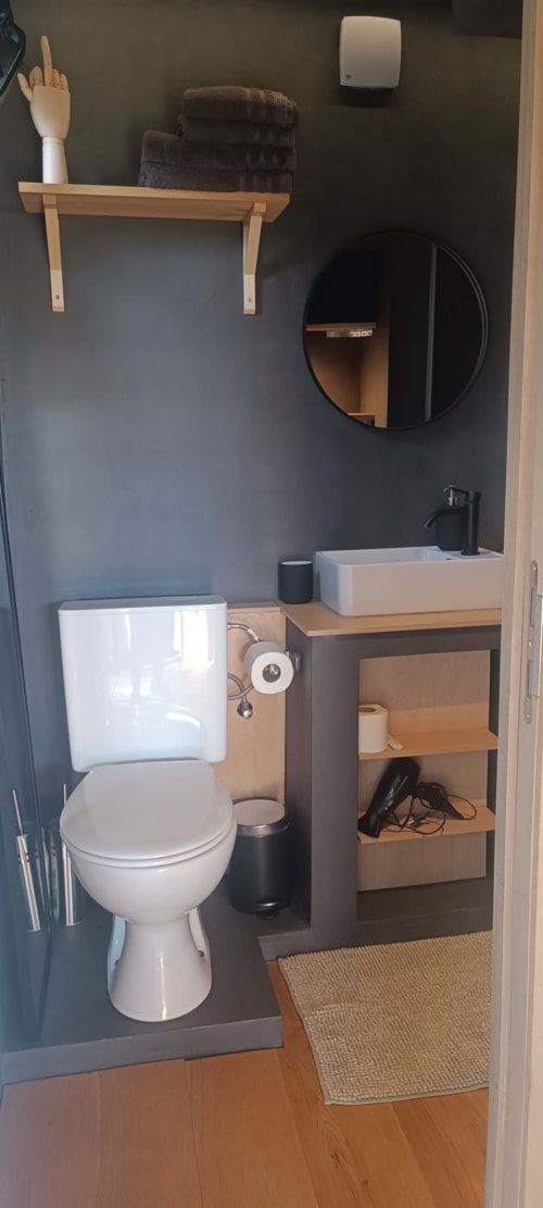 Modern bathroom in LEGO HOUSE cottage at Les Refuges Du Chalet, Jalhay with toilet, sink, and round mirror