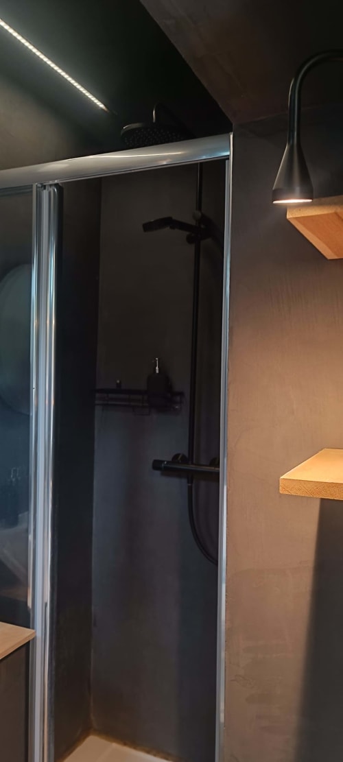 Modern black shower enclosure with rainfall showerhead at Les Refuges Du Chalet cottage in Jalhay