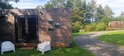 Modernes Holzchalet mit schwarzen Türen und Spiegelakzenten bei Les Refuges Du Chalet, Jalhay, umgeben von grünem Rasen