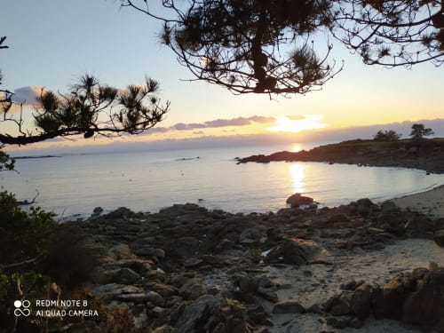 Vue du coucher de soleil depuis la plage des Logis de Kergoulou à Concarneau, France avec côte rocheuse