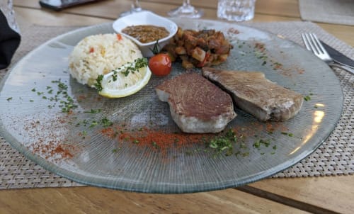 Deux steaks poêlés avec purée de pommes de terre, légumes rôtis et citron au restaurant Le Maquis Plage à Poggio-Mezzana