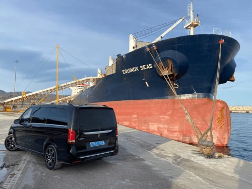 Furgoneta Mercedes negra estacionada en el puerto de Carboneras junto al buque de carga Equinox Seas en la terminal industrial