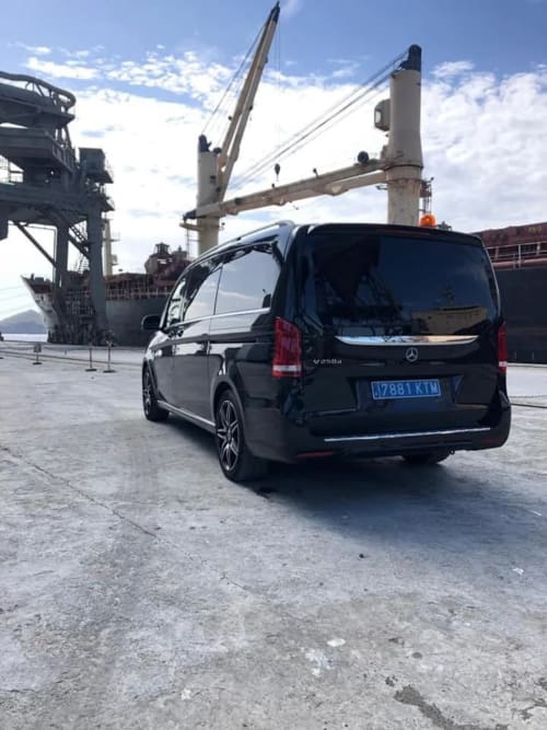 Furgoneta Mercedes negra en puerto de Carboneras con buque de carga y grúas de fondo
