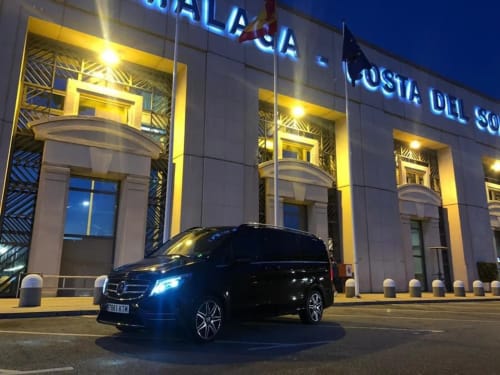 Mercedes SUV negro estacionado frente al Hostal Juan Carlos iluminado por la noche en Carboneras, España