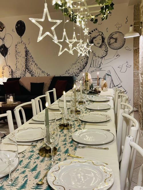 Table élégamment dressée à La Maison George avec décors étoilés néon et art mural festif à Flavigny-sur-Ozerain