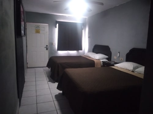 Habitación doble del Hotel Estrella en Matamoros con dos camas, almohadas blancas y piso de azulejos