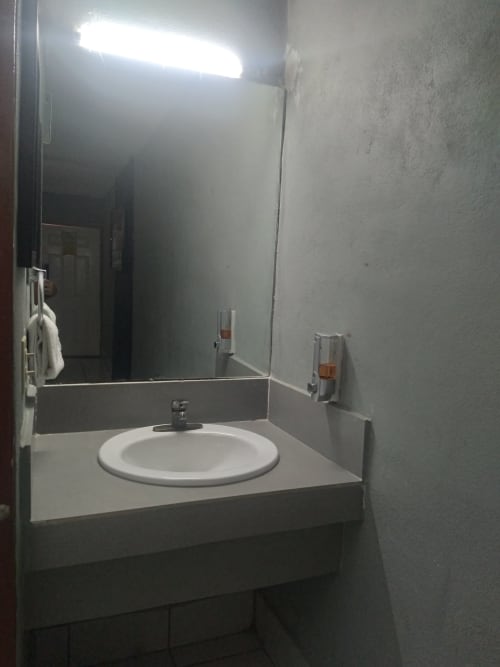 Moderno tocador de baño con lavamanos redondo y espejo en Hotel Estrella, Matamoros