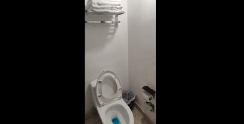 Baño limpio con inodoro y lavamanos del Hotel Estrella en Matamoros, toallas blancas y accesorios modernos