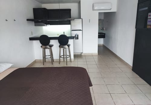 Habitación del Hotel Estrella en Matamoros con cama, kitchenette, barra y comodidades modernas