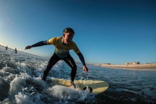 Surfista cavalgando uma onda na praia da Costa da Caparica perto do hostel Vila Alexandra em Portugal