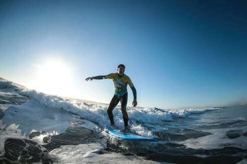 Surfer riding a wave at Costa da Caparica near Vila Alexandra hostel in Portugal