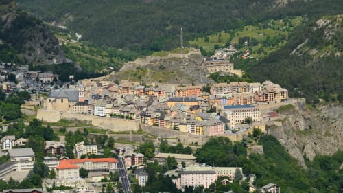 Aerial view of Montgenèvre alpine village nestled in mountain valley with historic fortifications