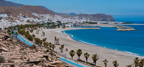 Playa de Carboneras con pueblo encalado, palmeras y aguas azules del Mediterráneo desde el Hostal Juan Carlos