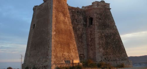 Torre de la fortaleza histórica al atardecer en Carboneras, España cerca del Hostal Juan Carlos