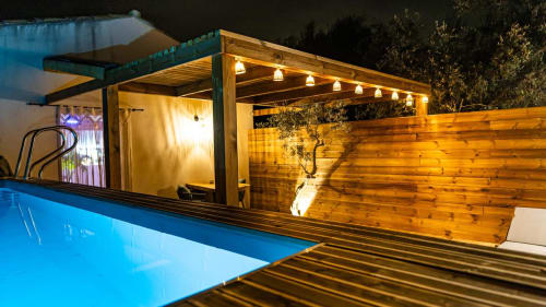 Terrasse piscine moderne à la Suite L'Olive Sacrée avec pergola en bois illuminée et espace spa à Cabannes, Provence