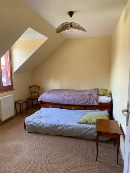 Chambre lumineuse sous les toits du gîte Accolade à Châteaudun, deux lits et vue sur le jardin