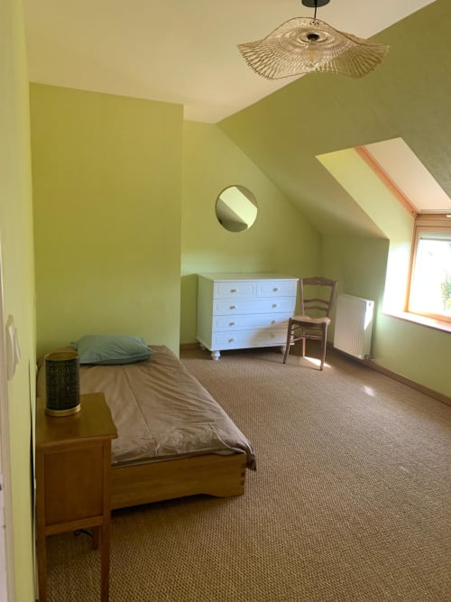 Chambre jaune-vert lumineux au gîte Accolade à Châteaudun avec lit simple, commode blanche et vue sur le jardin.