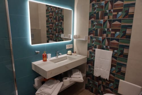 Moderno bagno presso La Dimora Di Ipno B&B a Vallata, Italia con pareti turchesi, specchio illuminato, vanity bianca e geometrico