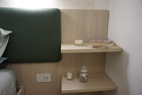 Moderno comodino in legno con candele, libri e decorazioni nella camera La Dimora Di Ipno, Vallata