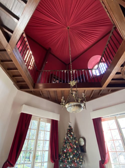 Elegant red pleated ceiling with crystal chandelier and Christmas tree at Domaine de Bize Mirepoix manor in Ariège, France