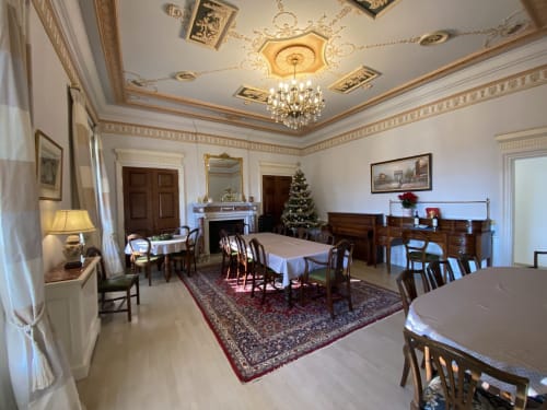 Elegant dining room at Domaine de Bize Mirepoix with crystal chandelier, fireplace, and decorated Christmas tree in Ariège,