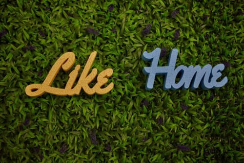 Cartello di benvenuto 'Like Home' su muschio verde, hotel L.H.A. a Ferrara, Italia