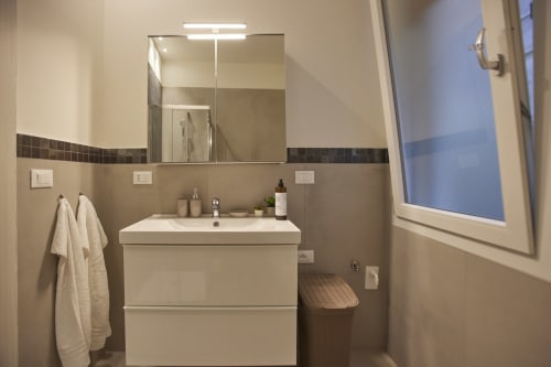 Modern bathroom vanity with mirror and lighting at LikeHome San Romano cottage in Ferrara, Italy
