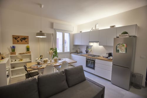 Modern open-plan kitchen and dining area in LikeHome San Romano cottage, Ferrara, with white cabinetry, stainless steel