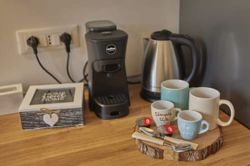 Coffee maker, electric kettle, and mugs on wooden table in LikeHome San Romano cottage, Ferrara