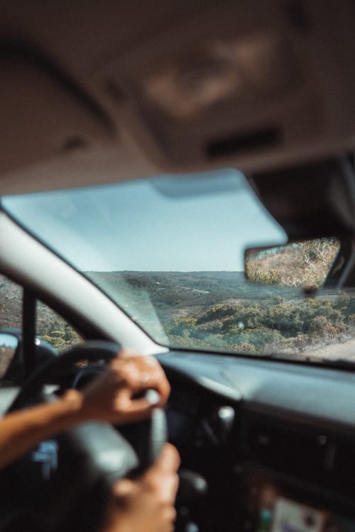 Vista do condutor pela janela do carro em Quinta Do Fraguil com as colinas verdes de Valença do Douro visíveis