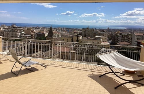 Terrazza sul tetto dell'Aparthotel Bentivoglio Catania con lettini, amaca, vista mare e paesaggio cittadino