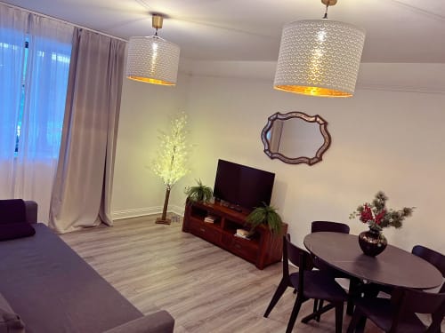 Modern Dublin apartment living room with TV, dining area, pendant lights, and city views at Temple Bar Suites
