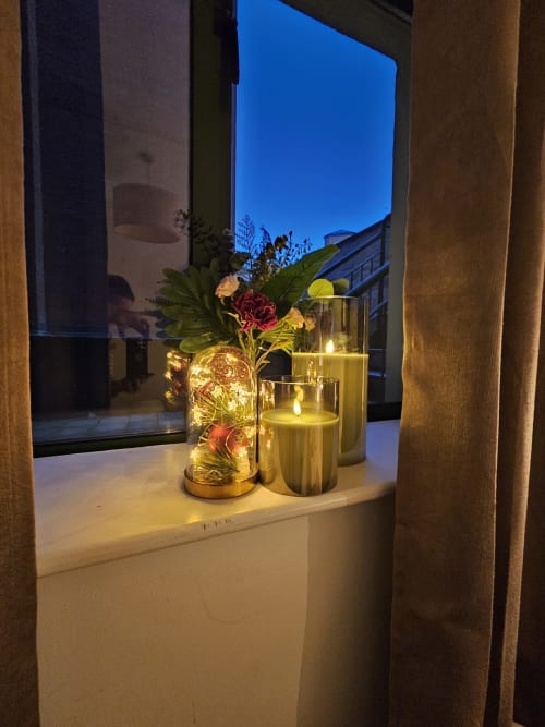 Evening window view at Dublin Exchange Suites with lit flowers, candles, and cityscape backdrop
