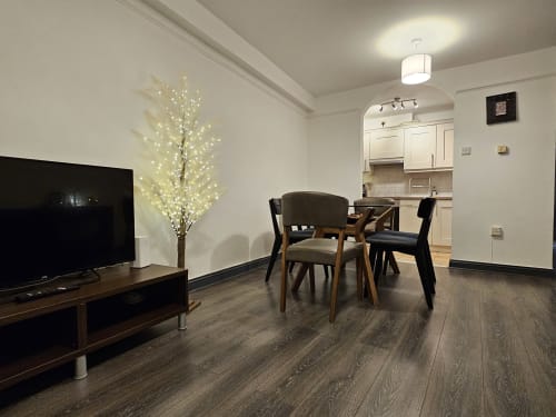 Exchange Suite at Dublin Exchange Suites: modern open-plan living area with dining table, TV, illuminated decorative tree,