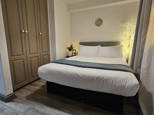 Modern bedroom in Dublin Exchange Suites family suite with double bed, gray headboard, white bedding, illuminated decorative