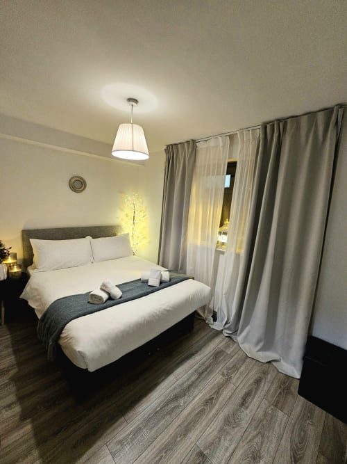 Modern bedroom in Dublin Exchange Suites family suite with queen bed, white linens, grey accents, pendant lighting, and