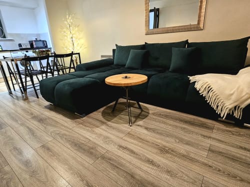 Modern living room with dark green sectional sofa, wooden table, and hardwood floors in Dublin Exchange Suites family