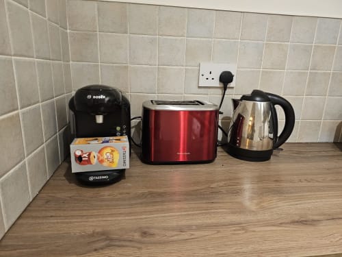Kitchen counter at Dublin Exchange Suites showing Bosch coffee machine, red toaster, and electric kettle appliances