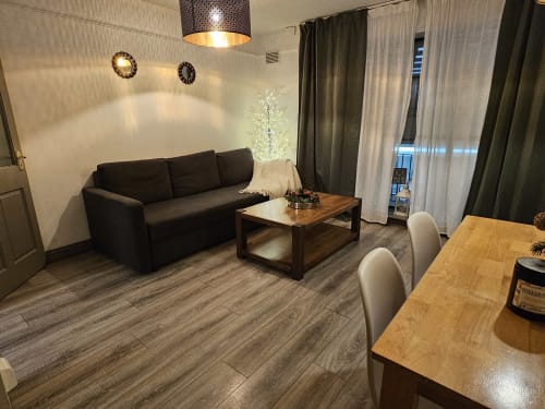 The Liffey Suite living area at Dublin Exchange Suites with black sofa, wooden coffee table, and dining area