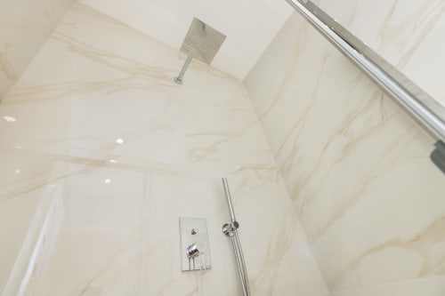 Modernes Marmor-Badezimmer mit Regenduschkopf an der Decke in den Magnolia Apartments Mailand