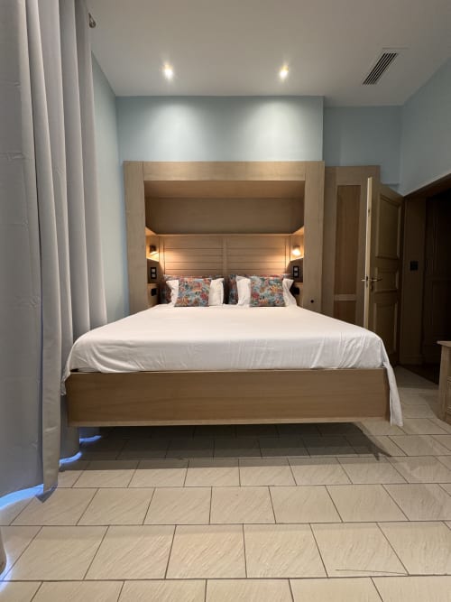 Chambre moderne avec lit intégré en bois, linge blanc et coussins motifs à l'appartement O Pitchoun, Mes à Moi Pézenas